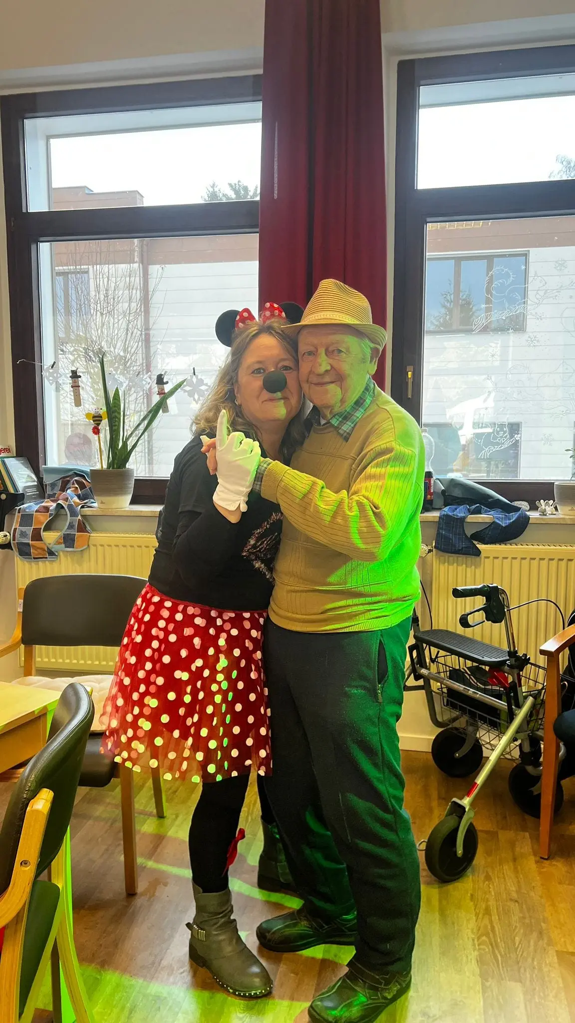Eine Betreuerin tanzt in Kostüm mit einem Tagespflegegast