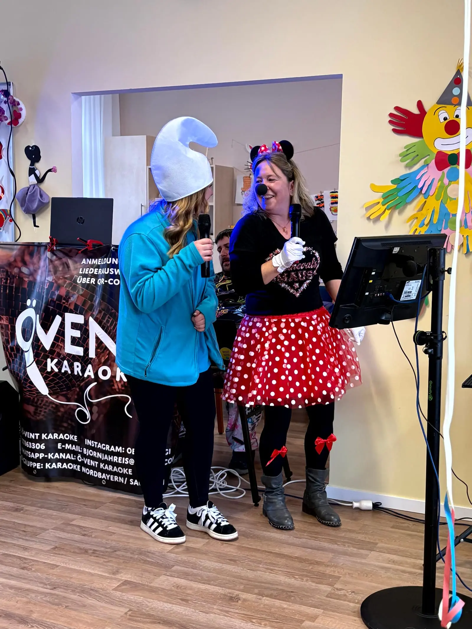 Zwei Betreuungskräfte singen beim Karaoke-Nachmittag ins Mikrofon