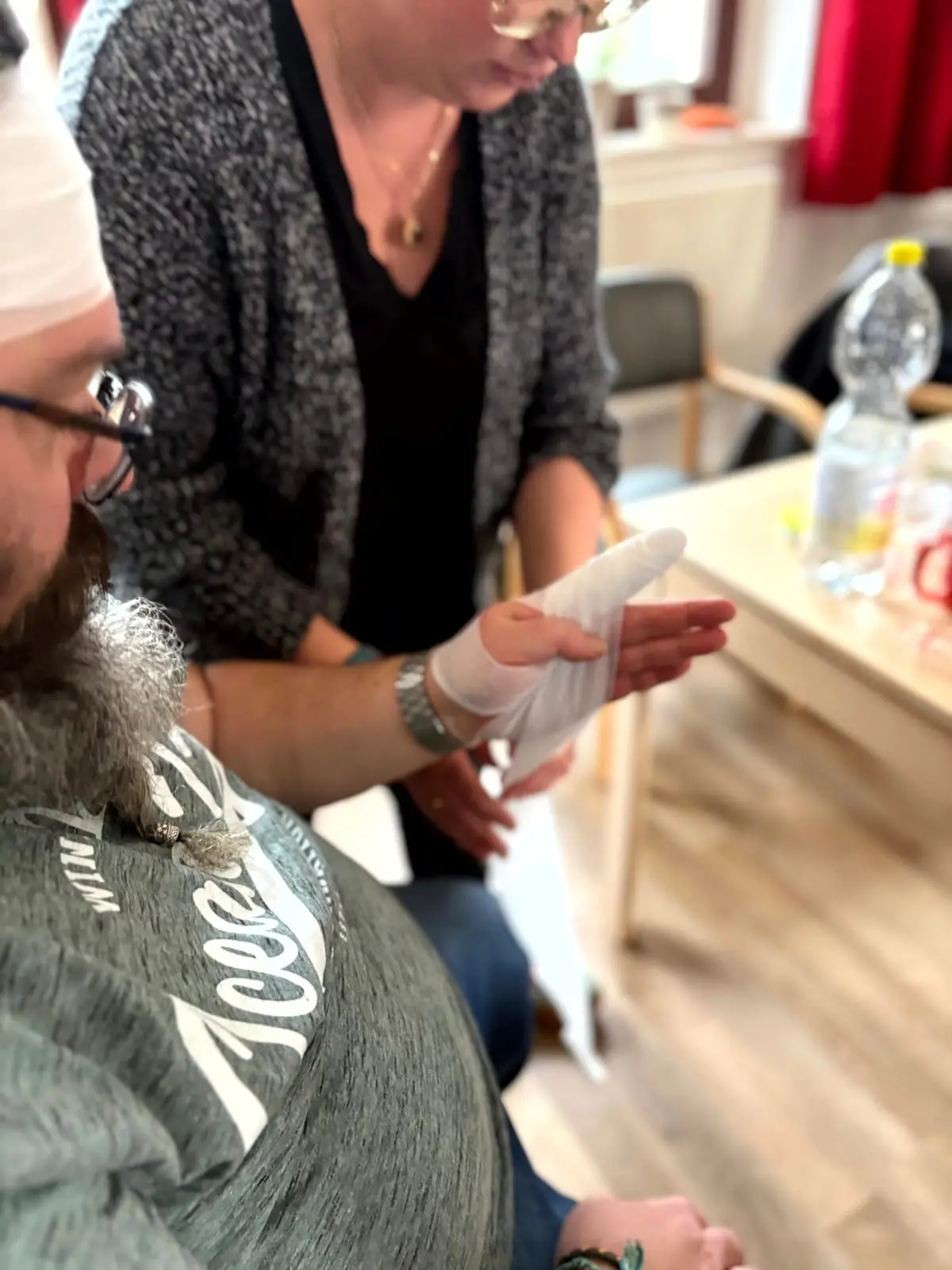 Bei der Erste-Hilfe-Schulung wird ein Verband an der Hand angelegt
