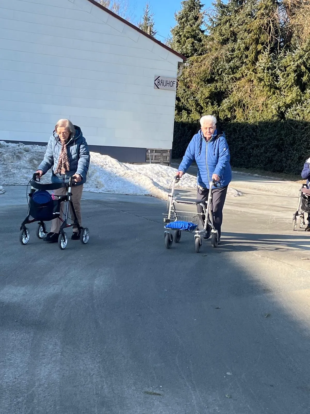 Zwei Gäste sind mit ihren Rollatoren auf dem Weg unterwegs